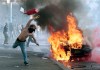 A protestor hurls a canister towards police next to a burning car during clashes in Rome, Saturday, Oct. 15, 2011. Protesters in Rome smashed shop windows and torched cars as violence broke out during a demonstration in the Italian capital, part of worldwide protests against corporate greed and austerity measures, entitled Occupy Wall Street. (AP Photo/Gregorio Borgia)