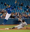 New York Yankees DJ LeMahieu is safe stealing third base as Toronto Blue Jays Richard Urena leaps for the throw from catcher Reese McGuire in the seventh inning of their American League baseball game in Toronto, Sunday, September 15, 2019. THE CANADIAN PRESS/Fred Thornhill