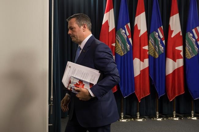 Premier Jason Kenney carries a copy of The Canadian Constitution after addressing the media in Edmonton, Alberta, on Tuesday October, 22, 2019. THE CANADIAN PRESS/Amber Bracken