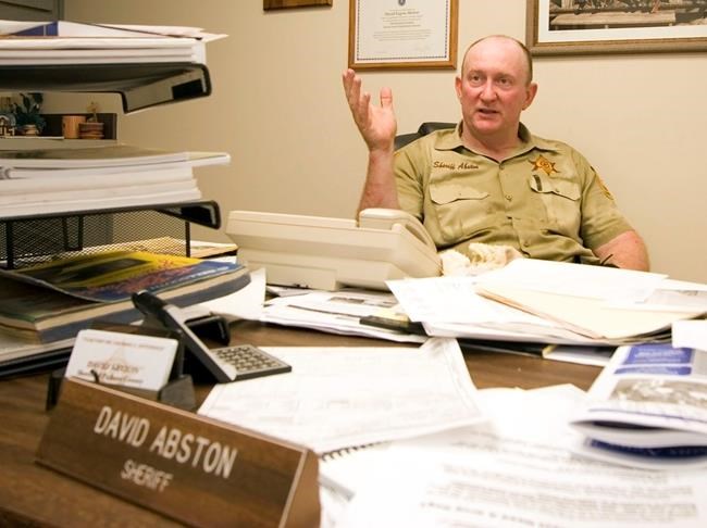 In this July 7, 2006 photo, Pickens County Sheriff David Abston speaks with reporters about a jailbreak in Carrollton, Ala. Court records show Abston was arrested Friday, June 14, 2019, and is pleading guilty to fraud and filing a false tax return. He is charged with scamming a food bank and his own church to pocket thousands under a law that let state sheriffs profit from feeding prisoners. (Dusty Compton/The Tuscaloosa News via AP)