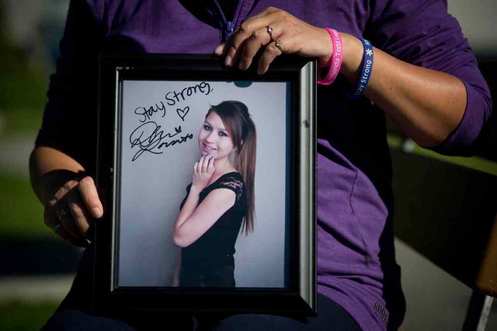 CP
Carol Todd holds a photo of her late daughter, Amanda Todd, signed by singer Demi Lovato with the words 'Stay Strong.'
