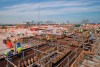 FILE - In this Wednesday, Oct. 31, 2018 file photo, men work on the construction site of the Ras Abu Aboud stadium, backdropped by the city skyline in Doha, Qatar. A FIFA feasibility study concluded the 2022 World Cup can expand to 48 teams by using at least one of Qatar's neighbors as an additional host, and found there is a low legal risk to changing the format and an additional $400 million in revenue could be generated The Associated Press obtained a copy of the 81-page report on Monday, March 11, 2019 that assesses the political, logistical and legal issues surrounding adding 16 teams _ a significant change to the format more than eight years after Qatar won the hosting rights. (AP Photo/Vadim Ghirda, File)