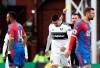 Crystal Palace's Jordan Ayew, left, receives a yellow card from Referee Michael Oliver, during the English Premier League soccer match between Crystal Palace and Fulham at Selhurst Park, in London, Saturday Feb. 2, 2019. (Jonathan Brady/PA via AP)