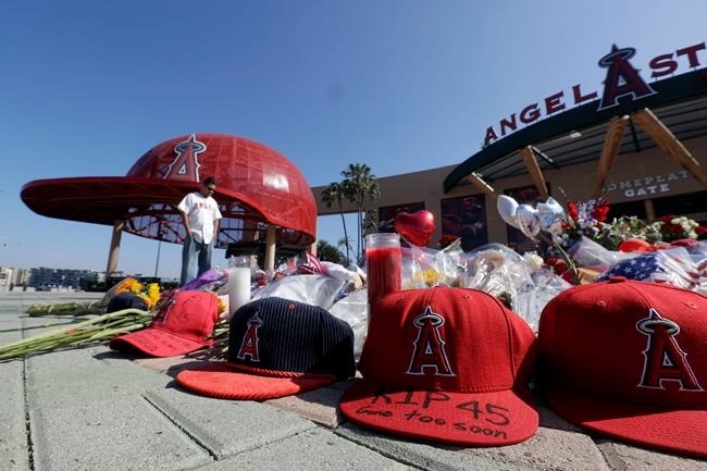 Angel Lozano looks over at a memorial as he give his condolences for Los Angeles Angels pitcher Tyler Skaggs outside Angel Stadium in Anaheim, Calif., Tuesday, July 2, 2019. The 27-year-old left-hander died in his Texas hotel room, where he was found unresponsive Monday afternoon. (AP Photo/Chris Carlson)