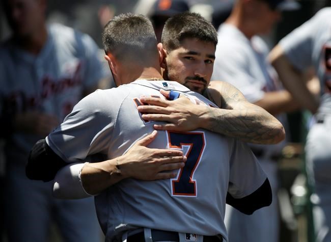Detroit Tigers' Nicholas Castellanos, right, hugs farewell to Jordy Mercer in the dugout, after Castellanos is traded to the Chicago Cubs, during the first inning of a baseball game against the Los Angeles Angels in Anaheim, Calif., Wednesday, July 31, 2019. (AP Photo/Alex Gallardo)