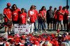 Fans stand next to a makeshift shrine in honor of Los Angeles Angels pitcher Tyler Skaggs outside Angel Stadium before the team's baseball game against the Seattle Mariners on Friday, July 12, 2019, in Anaheim, Calif. (AP Photo/Marcio Jose Sanchez)
