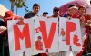 Fans hold up signs during during a news conference aboiut Los Angeles Angels center fielder Mike Trout's 12-year, $426.5 million contract, prior to the team's exhibition baseball game against the Los Angeles Dodgers on Sunday, March 24, 2019, in Anaheim, Calif. (AP Photo/Mark J. Terrill)