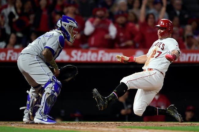 Los Angeles Angels' Mike Trout, right, scores on a single by Albert Pujols as Kansas City Royals catcher Martin Maldonado waits for the ball during the seventh inning of a baseball game Friday, May 17, 2019, in Anaheim, Calif. (AP Photo/Mark J. Terrill)