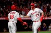 Los Angeles Angels' Mike Trout, right, is greeted by Brian Goodwin after he scored on a single by Albert Pujols during the first inning of a baseball game against the Milwaukee Brewers, Tuesday, April 9, 2019, in Anaheim, Calif. (AP Photo/Jae C. Hong)