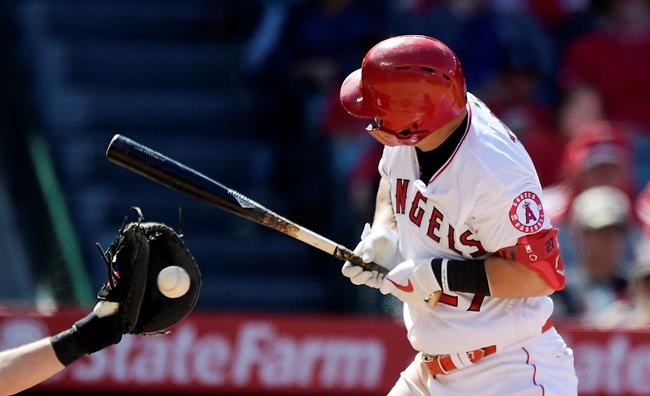 Los Angeles Angels' Mike Trout, right, winces as he is hit by a pitch while Kansas City Royals catcher Cam Gallagher catches during the seventh inning of a baseball game Sunday, May 19, 2019, in Anaheim, Calif. (AP Photo/Mark J. Terrill)