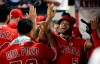 Los Angeles Angels' Albert Pujols, right, is congratulated in the dugout after scoring on a single by Brian Goodwin during the seventh inning of a baseball game against the Texas Rangers on Tuesday, Aug. 27, 2019, in Anaheim, Calif. (AP Photo/Marcio Jose Sanchez)