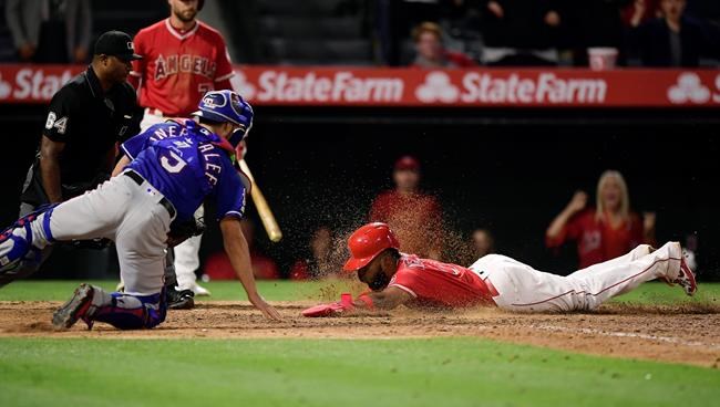 Los Angeles Angels' Luis Rengifo, right, scores on a double by Kole Calhoun as Texas Rangers catcher Isiah Kiner-Falefa reaches for a late tag during the ninth inning of a baseball game Saturday, May 25, 2019, in Anaheim, Calif. (AP Photo/Mark J. Terrill)