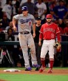 Los Angeles Dodgers' Corey Seager, left, winces after injuring himself while rounding third on a single by Alex Verdugo as Los Angeles Angels third baseman David Fletcher stands by during the ninth inning of a baseball game, Tuesday, June 11, 2019, in Anaheim, Calif. (AP Photo/Mark J. Terrill)