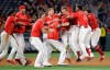 Los Angeles Angels' Dustin Garneau, third from right, is mobbed by teammates after driving in the game-winning run with a double during the ninth inning of a baseball game against the Oakland Athletics Wednesday, June 5, 2019, in Anaheim, Calif. Los Angeles won 10-9. (AP Photo/Marcio Jose Sanchez)