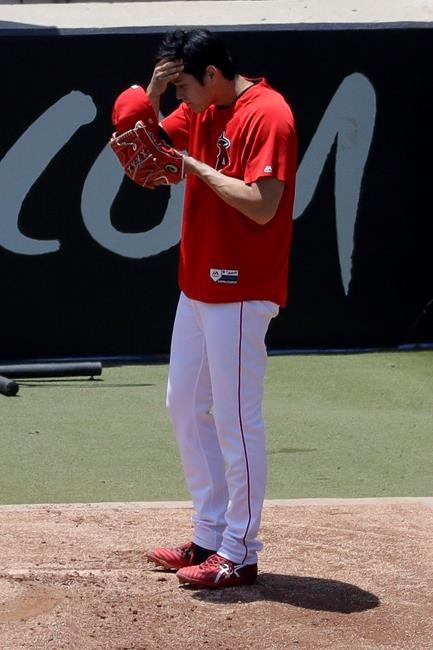 Los Angeles Angels' Shohei Ohtani wipes his face after throwing in the bullpen before a baseball game against the Cincinnati Reds in Anaheim, Calif., Wednesday, June 26, 2019. Ohtani threw off a mound for the first time since Tommy John surgery Oct 1, 2018. (AP Photo/Chris Carlson)