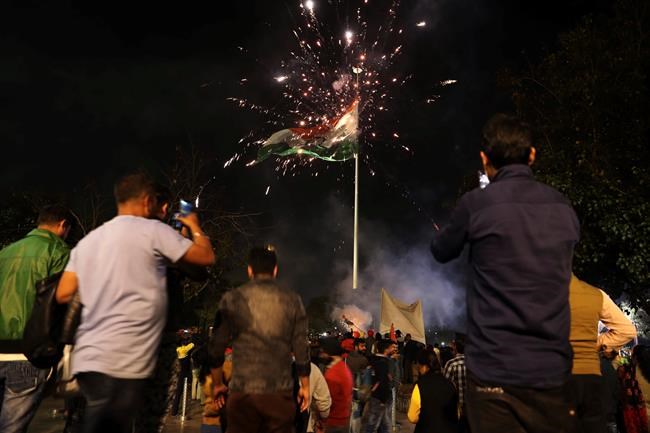 Crackers burst beside a giant Indian national flag as supporters of India's ruling Bhartiya Janata Party celebrate reports of Indian aircrafts bombing Pakistan territory, in New Delhi, India, Tuesday, Feb. 26, 2019. A pre-dawn airstrike inside Pakistan that India said targeted a terrorist training camp and killed a