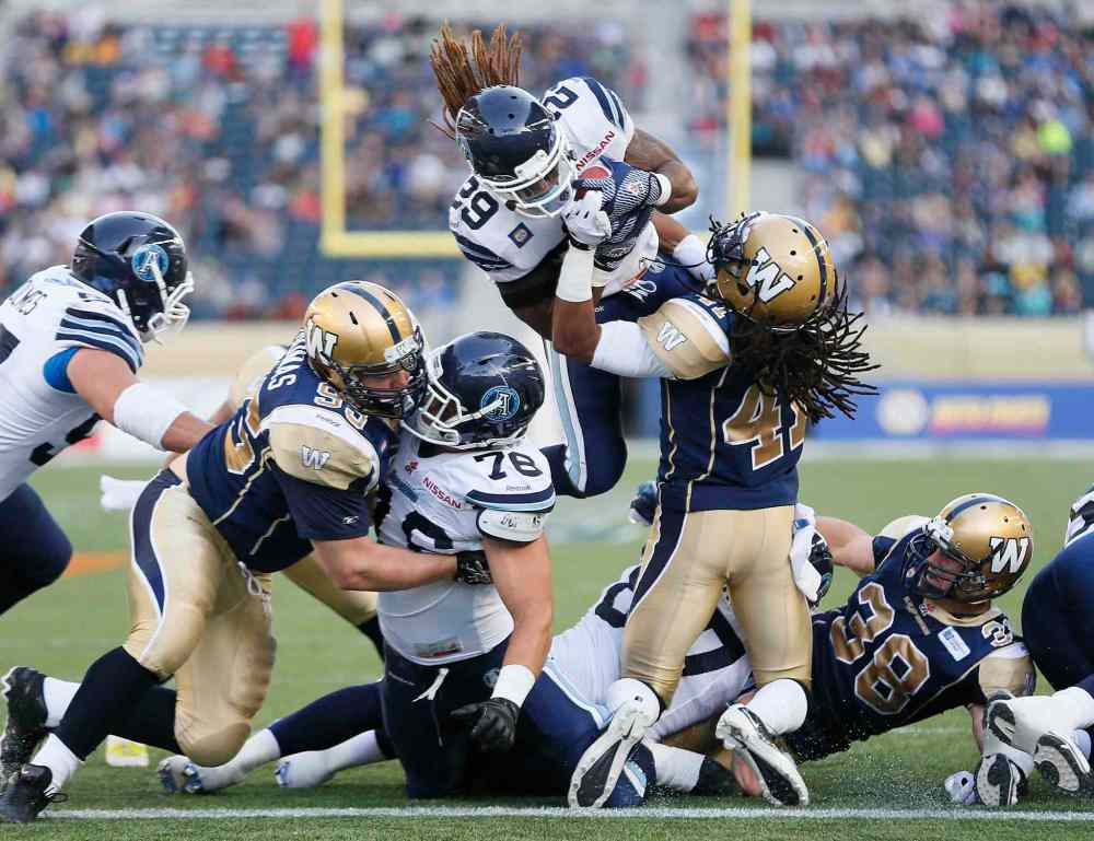 JOHN WOODS / WINNIPEG FREE PRESS
Winnipeg Blue Bombers defender Don Unamba (41) can't stop Toronto Argonauts running back Curtis Steele from flying in for a touchdown during the first half of a CFL pre-season game at Investors Group Field in Winnipeg Monday.