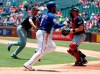 Texas Rangers shortstop Elvis Andrus (1) sprints home scoring on a wild pitch by Cleveland Indians' Shane Bieber, left rear, as catcher Kevin Plawecki moves to cover the plate in the first inning of a baseball game in Arlington, Texas, Thursday, June 20, 2019. (AP Photo/Tony Gutierrez)