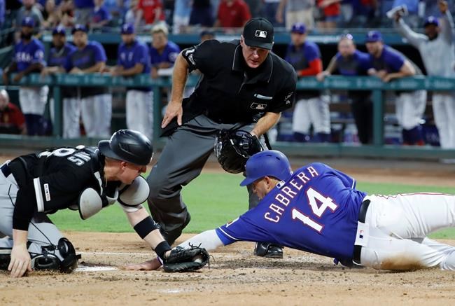 Chicago White Sox catcher Zack Collins, left, reaches to tag out Texas Rangers' Asdrubal Cabrera (14) as umpire Ed Hickox looks on in the first inning of a baseball game in Arlington, Texas, Saturday, June 22, 2019. Cabrera was trying to score on a double by Logan Forsythe. (AP Photo/Tony Gutierrez)