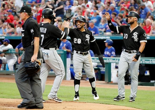 Umpire Ed Hickox stands by the plate as Chicago White Sox's Yonder Alonso, Leury Garcia (28) and Yoan Moncada (10) celebrate scoring on a Tim Anderson bases-clearing double in the first inning of a baseball game against the Texas Rangers in Arlington, Texas, Saturday, June 22, 2019. (AP Photo/Tony Gutierrez)