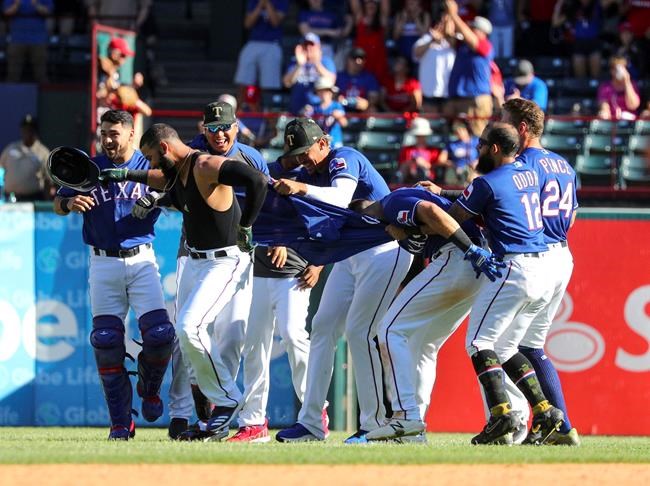 The Texas Rangers rip the jersey off of Nomar Mazara after his sacrifice fly scored Danny Santana for a win over the St. Louis Cardinals in the 10th inning of a baseball game Sunday, May 19, 2019, in Arlington, Texas. (AP Photo/ Richard W. Rodriguez)