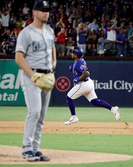 Seattle Mariners' Wade LeBlanc stands on the mound as Texas Rangers' Willie Calhoun, rear, rounds the bases after hitting a three-run home run during the fifth inning of a baseball game in Arlington, Texas, Wednesday, July 31, 2019. (AP Photo/Tony Gutierrez)