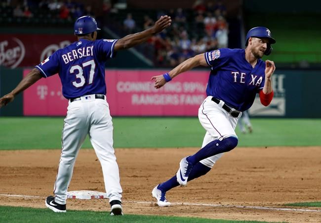 Texas Rangers third base coach Tony Beasley (37) waves Hunter Pence (24) home as Pence scores on a Nomar Mazara double during the sixth inning of a baseball game against the Seattle Mariners in Arlington, Texas, Tuesday, May 21, 2019. (AP Photo/Tony Gutierrez)