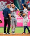 Houston Astros shortstop Alex Bregman (2) is tended to by second baseman Jose Altuve (27) and a trainer after taking a ground ball by Texas Rangers' Shin-Soo Choo (17) to the face during the third inning of a baseball game Thursday, July 11, 2019, in Arlington, Texas. Bregman left the game because of the injury and was replaced by Myles Shaw. (AP Photo/Jeffrey McWhorter)