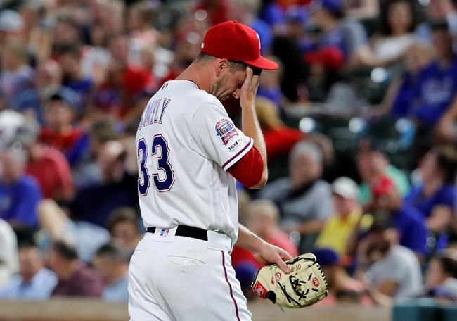 Texas Rangers' Drew Smyly wipes his face as he walks to the dugout after turning the ball over during the seventh inning of the team's baseball game against the Cleveland Indians in Arlington, Texas, Tuesday, June 18, 2019. Smyly gave up three solo home runs to the Indians in the inning. (AP Photo/Tony Gutierrez)