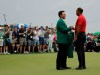 Patrick Reed helps Tiger Woods with his green jacket after Woods won the Masters golf tournament Sunday, April 14, 2019, in Augusta, Ga. (AP Photo/Charlie Riedel)