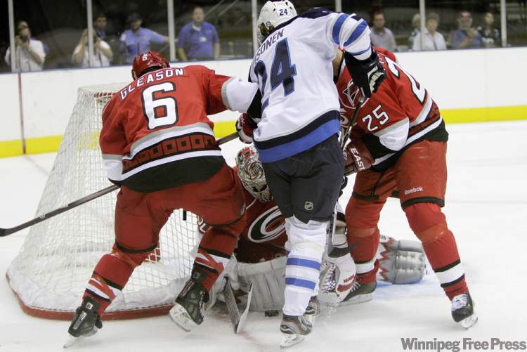 Rick Havner / The Associated Press
Winnipeg Jets' Janne Pesonen works between Carolina Hurricanes' Tim Gleason (6) and Joni Pitkanen (25) in front of Carolina goalie Cam Ward.