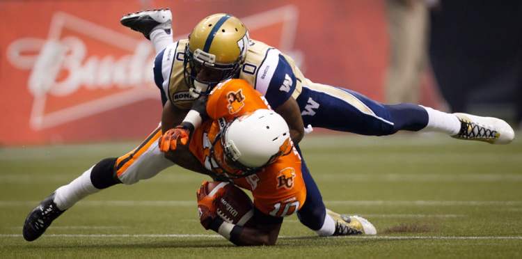 Darryl Dyck / The Canadian Press
The B.C. Lions' Kierrie Johnson (bottom) is tackled by the Winnipeg Blue Bombers' Johnny Sears after making a reception that was called back due to penalties against both teams during the first half in Vancouver on Friday.