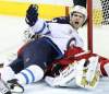 Stuart Gradon / Postmedia News
Calgary Flames goalie Miikka Kiprusoff lies under the Winnipeg Jets' Jim Slater during second-period action at the Scotiabank Saddledome in Calgary Friday. The Flames won 5-3.