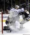 Terry Gilliam / The Associated Press
The Winnipeg Jets' Evander Kane (centre) is hit by Columbus Blue Jackets goalie Steve Mason (left) and Grant Clitsome (14) during the first period in Columbus, Ohio, on Saturday.