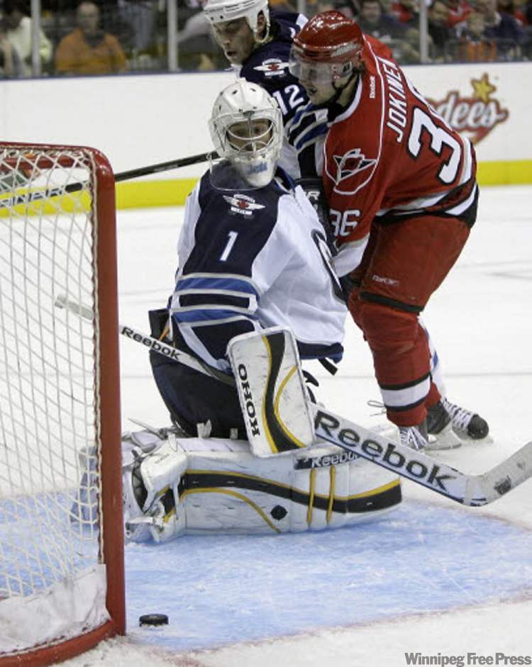 Rick Havner / The Associated Press
Jets goalie David Aebischer watches a shot by Carolina Hurricanes' Jussi Jokinen slide past the net Sunday.