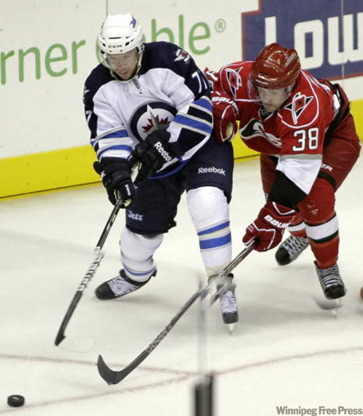 Rick Havner / The Associated Press
Winnipeg Jets' Kevin Clark (left) and Carolina Hurricanes' Ryan Murphy race for the puck during the third period of their game in Charlotte, N.C., Sunday.