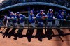 Texas Rangers players wait in the dugout before a spring training baseball game against the Kansas City Royals Saturday, Feb. 23, 2019, in Surprise, Ariz. (AP Photo/Charlie Riedel)