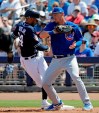 San Diego Padres' Fernando Tatis Jr., left, returns safely to first base on a pickoff attempt as Chicago Cubs first baseman Jim Adduci turns toward him during the second inning of a spring training baseball game Sunday, March 24, 2019, in Peoria, Ariz. (AP Photo/Elaine Thompson)