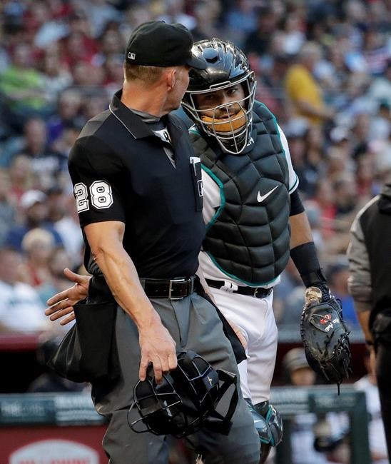Arizona Diamondbacks catcher Alex Avila interacts with home plate umpire Jim Wolf as Wolf leaves the game after being hit by a foul ball off the bat of New York Mets' Todd Frazier during the second inning of a baseball game, Friday, May 31, 2019, in Phoenix. (AP Photo/Matt York)