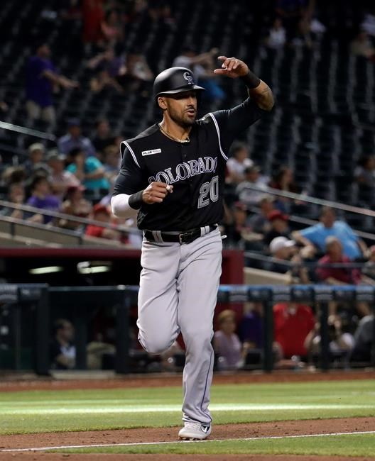 Colorado Rockies' Ian Desmond (20) scores on a base hit by Chris Iannetta during the 10th inning of the team's baseball game against the Arizona Diamondbacks, Thursday, June 20, 2019, in Phoenix. The Rockies won 6-4. (AP Photo/Matt York)