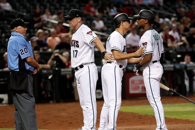 Arizona Diamondbacks manager Torey Lovullo (17) and third base coach Tony Perezchica hold back Jarrod Dyson, right after he was ejected by home plate umpire Tom Hallion during the eighth inning of the team's baseball game against the Philadelphia Phillies, Tuesday, Aug. 6, 2019, in Phoenix. (AP Photo/Matt York)