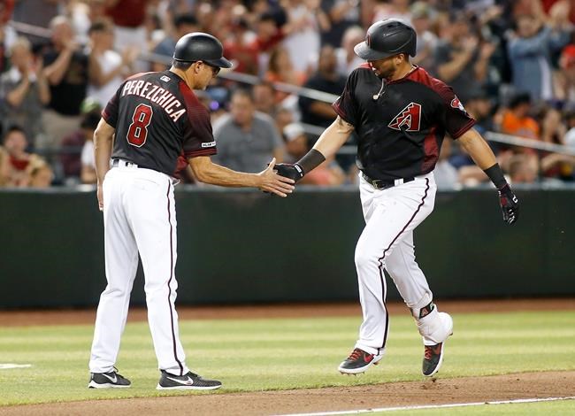 Arizona Diamondbacks' David Peralta, right, is congratulated by third base coach Tony Perezchica after hitting a solo home run against the San Francisco Giants during the fourth inning of a baseball game, Friday, May 17, 2019, in Phoenix. (AP Photo/Ralph Freso)