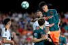 Ajax's Edson Alvarez, top, jumps for the ball against Valencia's Jaume Costa during the Champions League group H soccer match between Valencia and Ajax, at the Mestalla stadium in Valencia, Wednesday, Oct. 2, 2019. (AP Photo/Alberto Saiz)