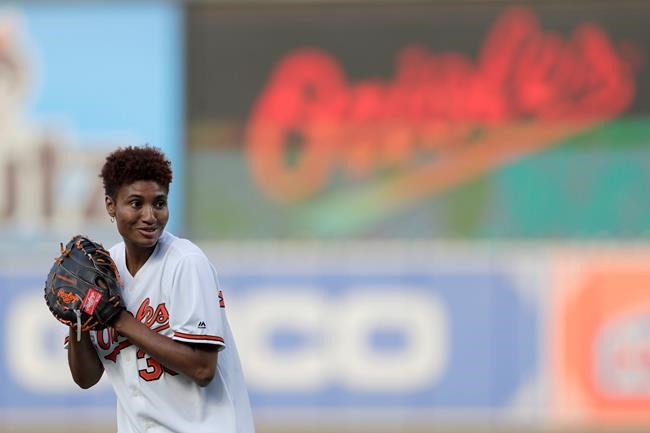 Angel McCoughtry, of WNBA basketball's Atlanta Dream, throws a ceremonial pitch prior to a baseball game between the Baltimore Orioles and the Toronto Blue Jays, Thursday, Aug. 1, 2019, in Baltimore. (AP Photo/Julio Cortez)