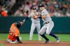 Houston Astros shortstop Carlos Correa, right, turns a double play as Baltimore Orioles' Jace Peterson (23) slides on a ball hit by Chance Sisco during the sixth inning of a baseball game Saturday, Aug. 10, 2019, in Baltimore. (AP Photo/Julio Cortez)