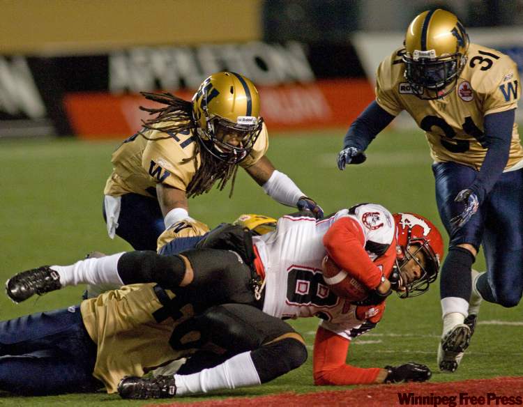 DAVID LIPNOWSKI / WINNIPEG FREE PRESS
Winnipeg Blue Bombers Alex Suber and Ian Logan take down Calgary Stampeders Romby Bryant during the last game of the 2010 season.