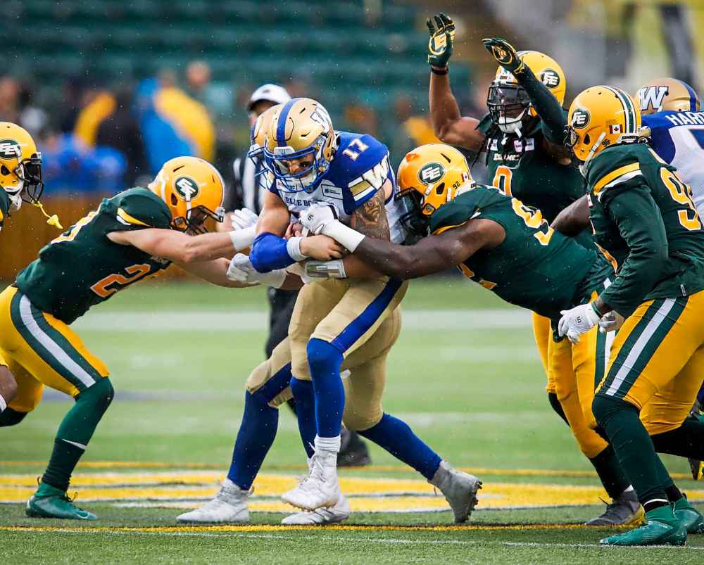 THE CANADIAN PRESS/Jeff McIntosh
Winnipeg Blue Bombers quarterback Chris Streveler, centre, is swarmed by Edmonton Eskimos' players during the first half in Edmonton, Friday.