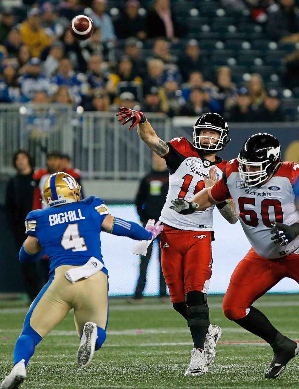 THE CANADIAN PRESS/John Woods
Calgary Stampeders quarterback Bo Levi Mitchell throws under pressure from the Winnipeg Blue Bombers' Adam Bighill during the first half in Winnipeg, Friday.