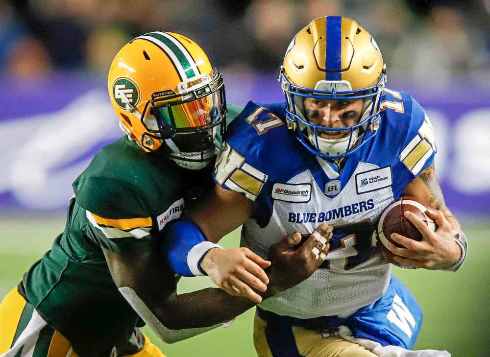 THE CANADIAN PRESS/Jeff McIntosh
Winnipeg Blue Bombers quarterback Chris Streveler, right, runs the ball as Edmonton Eskimos' Larry Dean tries to tackle him during second half CFL football action in Edmonton, Friday, Aug. 23, 2019.