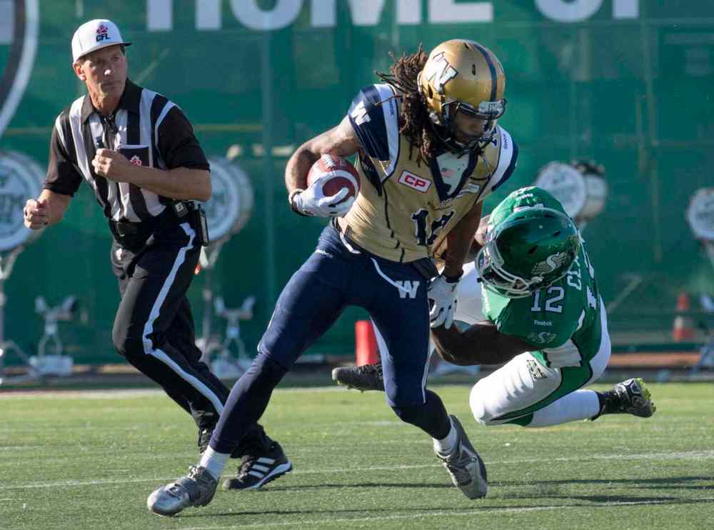 RICK ELVIN / THE CANADIAN PRESS
Saskatchewan Roughriders linebacker Telvion Clark tackles Winnipeg Blue Bombers wide receiver Justin Veltung during the first quarter of CFL football action in Regina, Sask., Saturday.